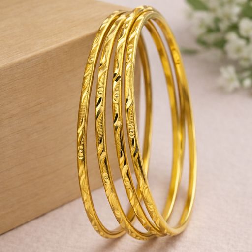 Celebrate the poetic beauty of nature with this set of four gold-toned bangles. Featuring a rhythmic, hand-finished vine and floral engraving, these bangles offer a masterclass in textural design, blending a timeless botanical silhouette with a modern, radiant luster.