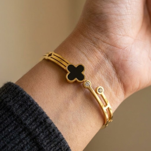 Embrace the height of modern luxury with this architecturally inspired gold-toned cuff. Featuring a striking black enamel focal point and a unique skeletal frame, this piece offers a sophisticated blend of Parisian charm and contemporary edge.